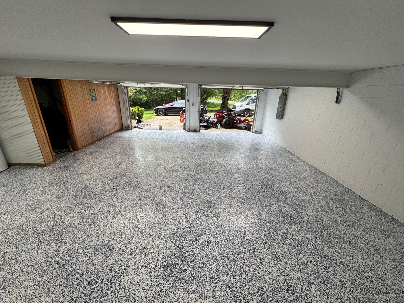 Gray flake epoxy floor in a two-car garage with open doors in Greensboro NC