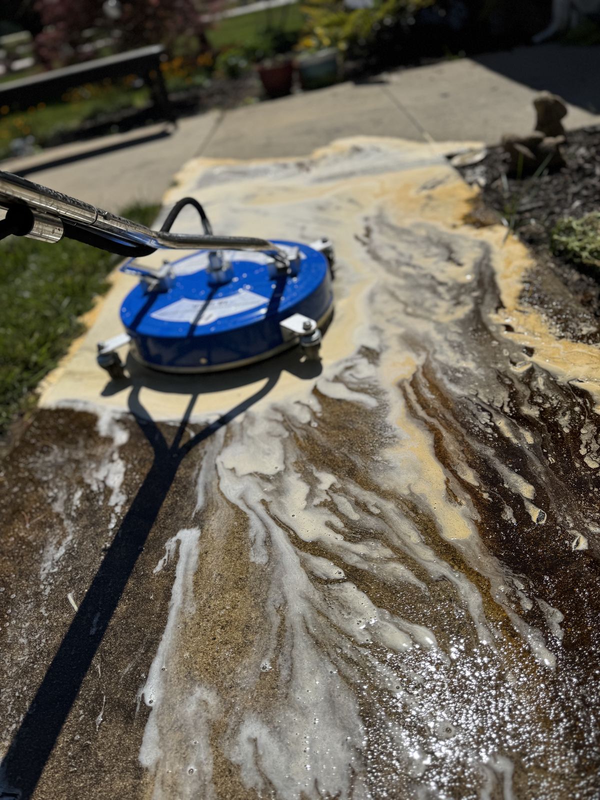 Close up of concrete pressure washing with surface cleaner