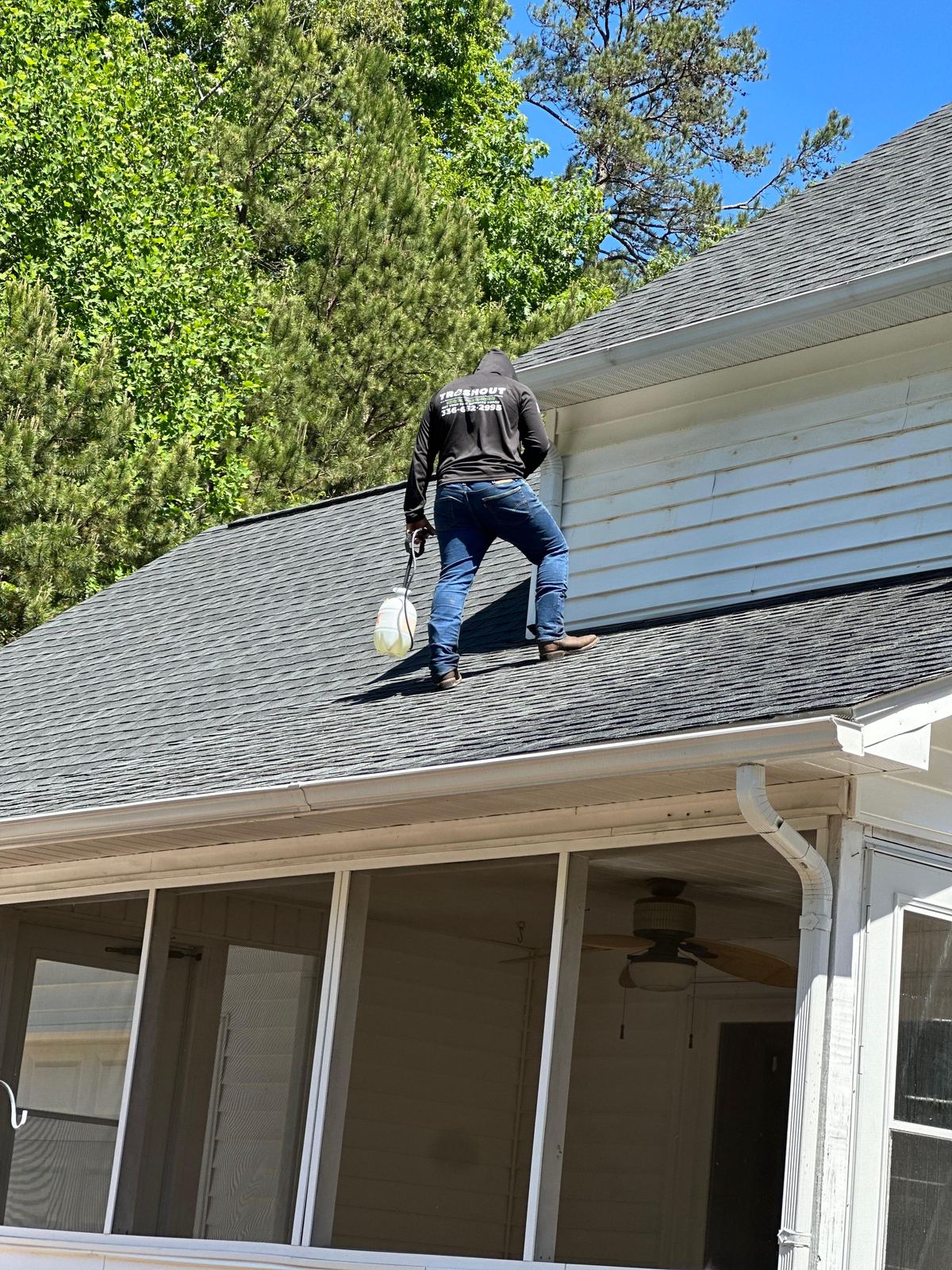 TrashOut technician working on roof washing service