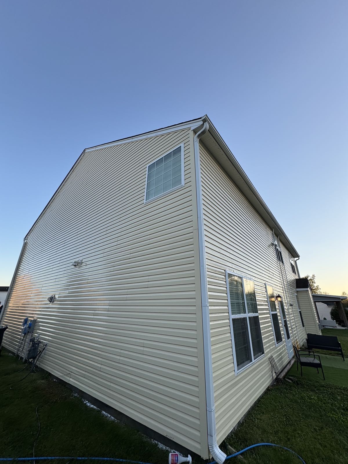 Clean yellow vinyl siding on a two-story home after soft washing in McLeansville NC