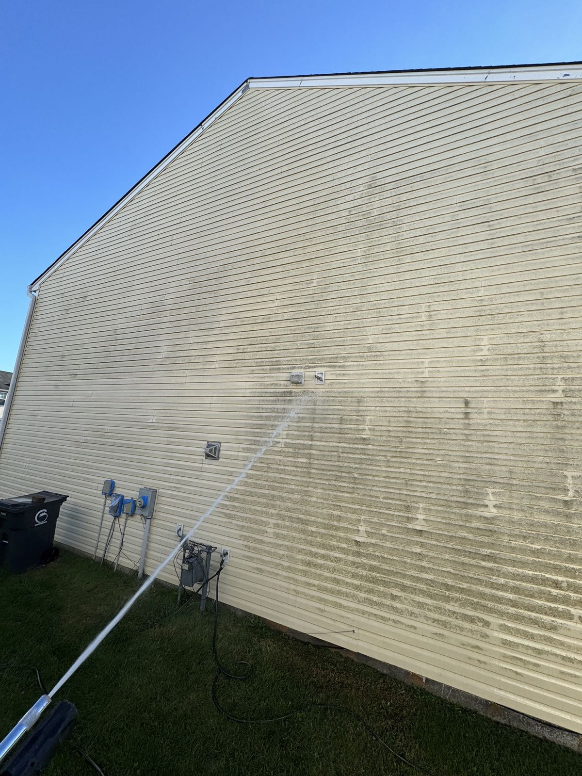 Heavy mold and dirt on yellow vinyl siding of a two-story home as soft washing begins in McLeansville NC